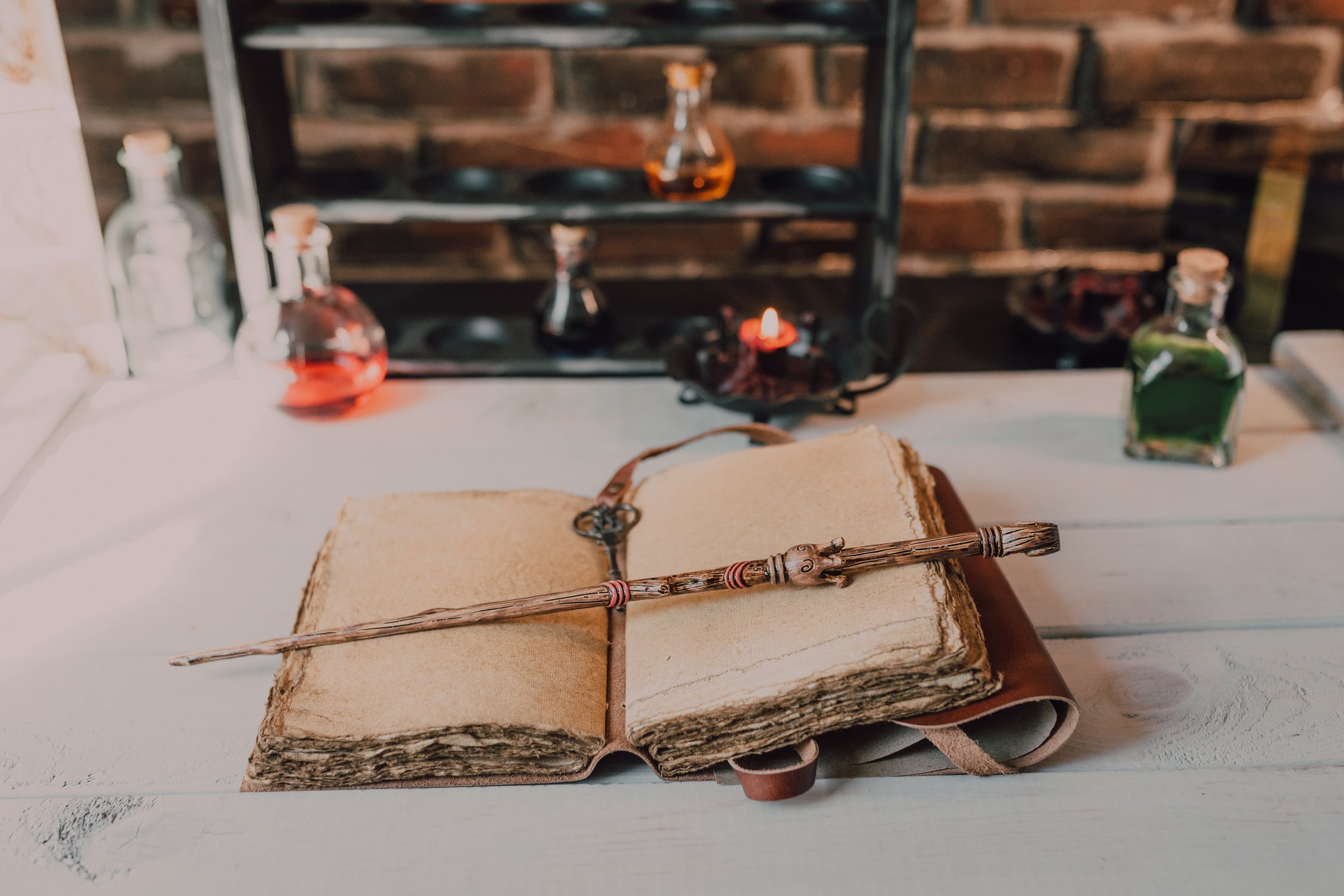 Close-Up Shot of a Spell Book and a Wand